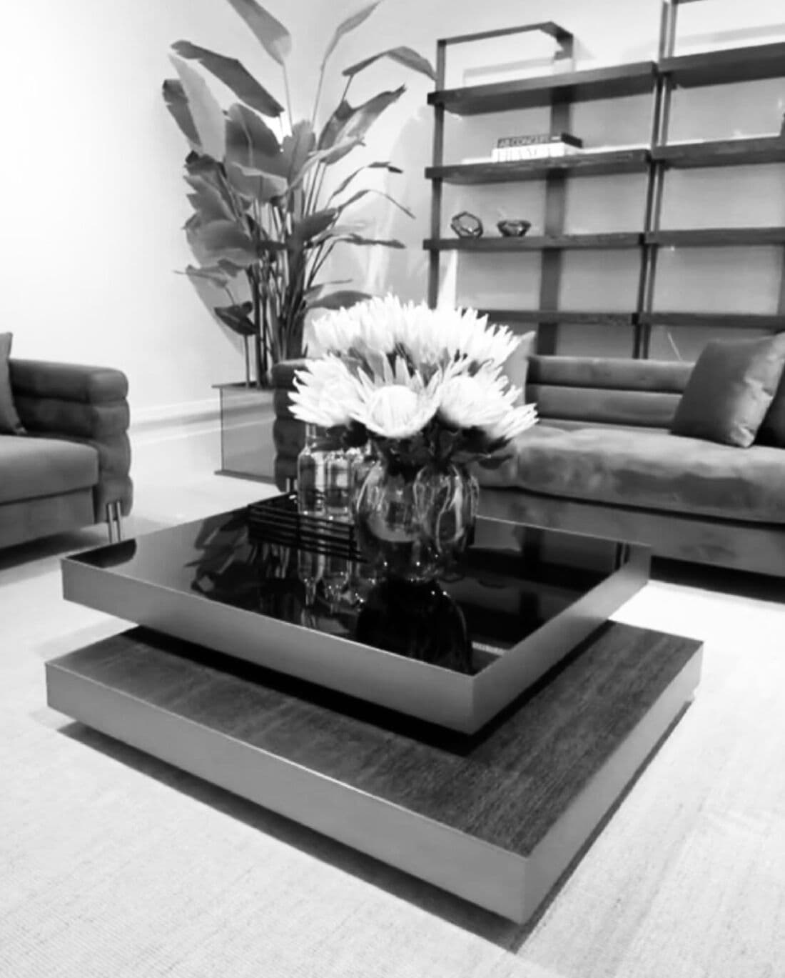 Salon du showroom : canapé, bibliothèque et compositions florales