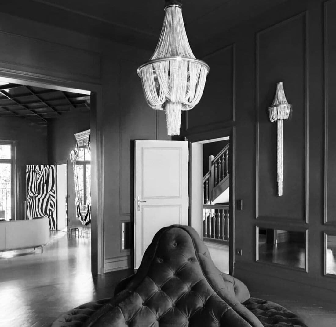Perspective du showroom : lustres, boiseries sombres et parquet
