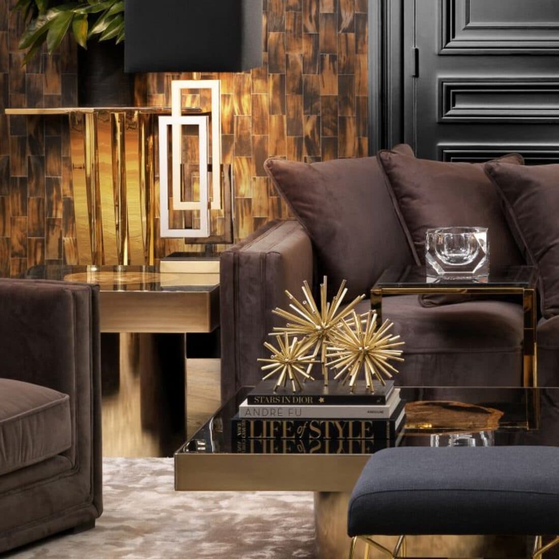 Mise en scène chaleureuse du showroom : canapé en velours brun, laiton et lumière dorée